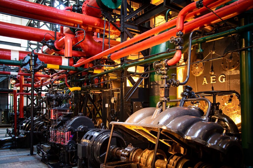 Vibrant industrial machinery with red pipes and complex equipment in a factory.