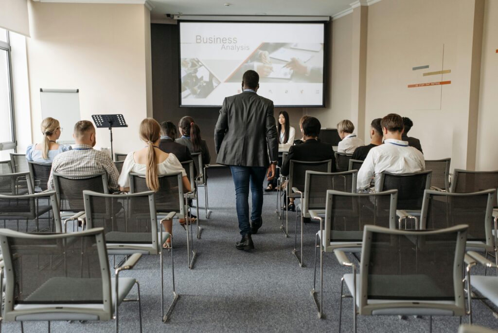 Business conference setting with diverse participants focusing on analysis presentation.